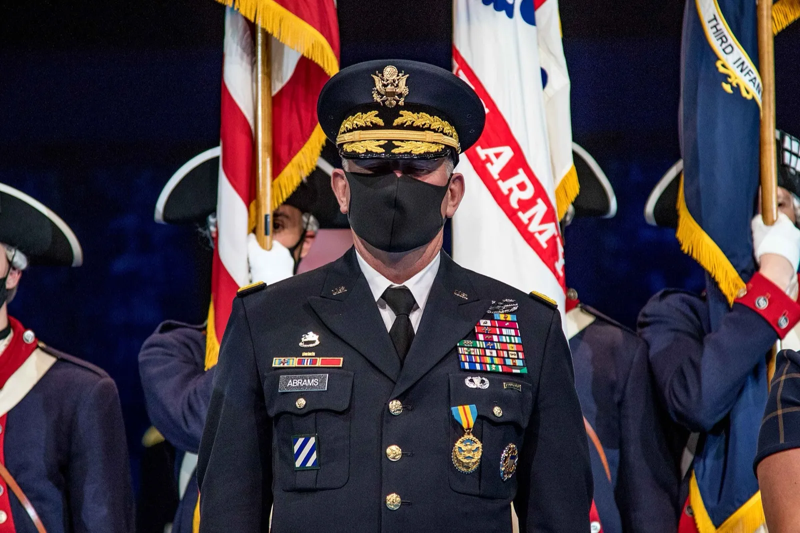 A military retirement ceremony with a service member being recognized in front of the flag