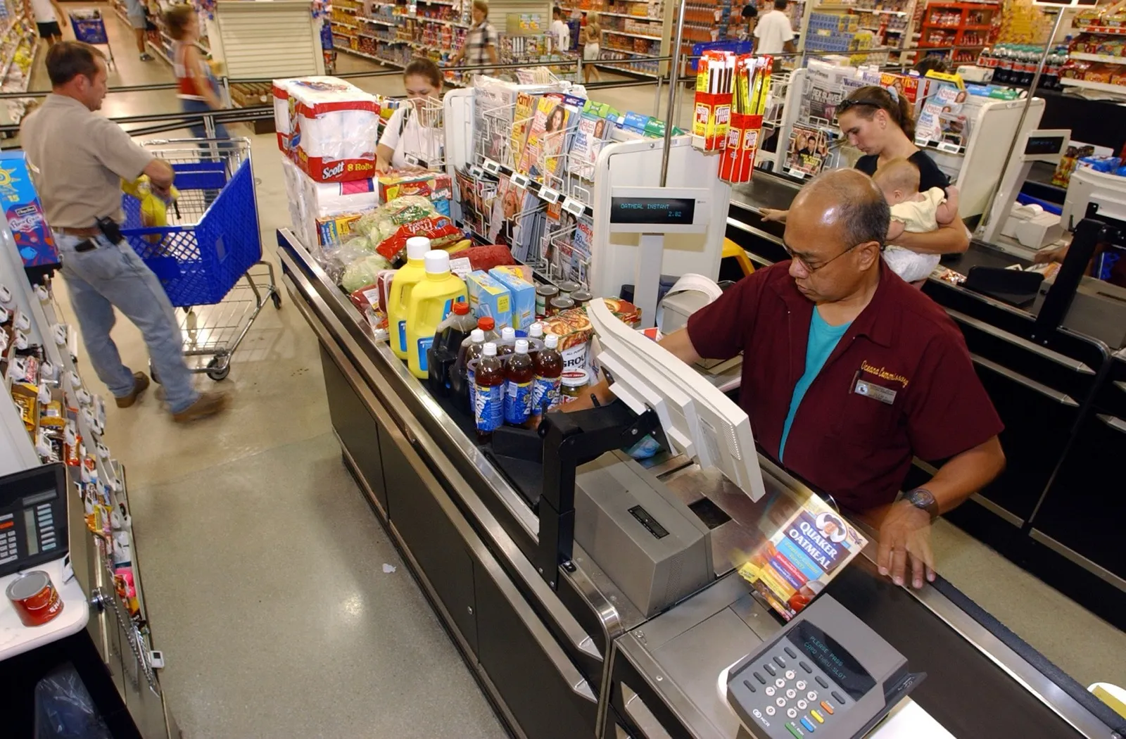Service members and families walking through a busy commissary in a high-cost stateside military community