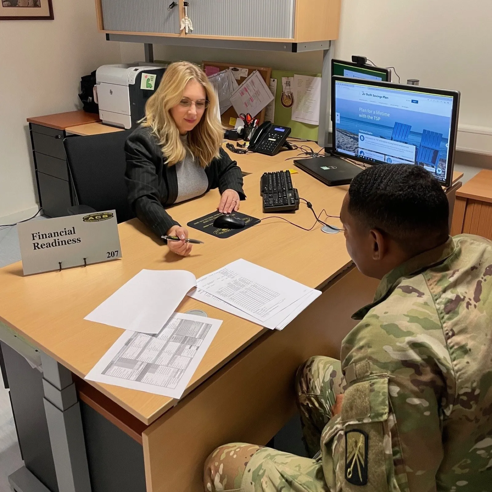 Service members at a financial readiness briefing reviewing retirement savings paperwork