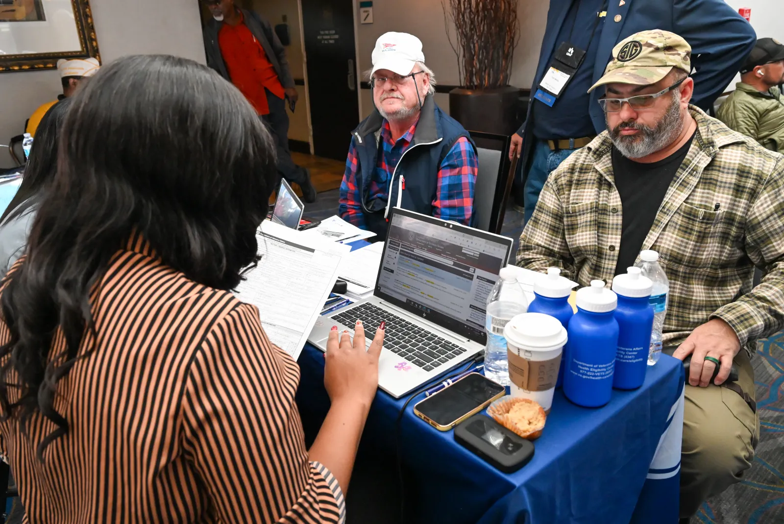 A veteran reviewing a VA disability benefits letter at a kitchen table