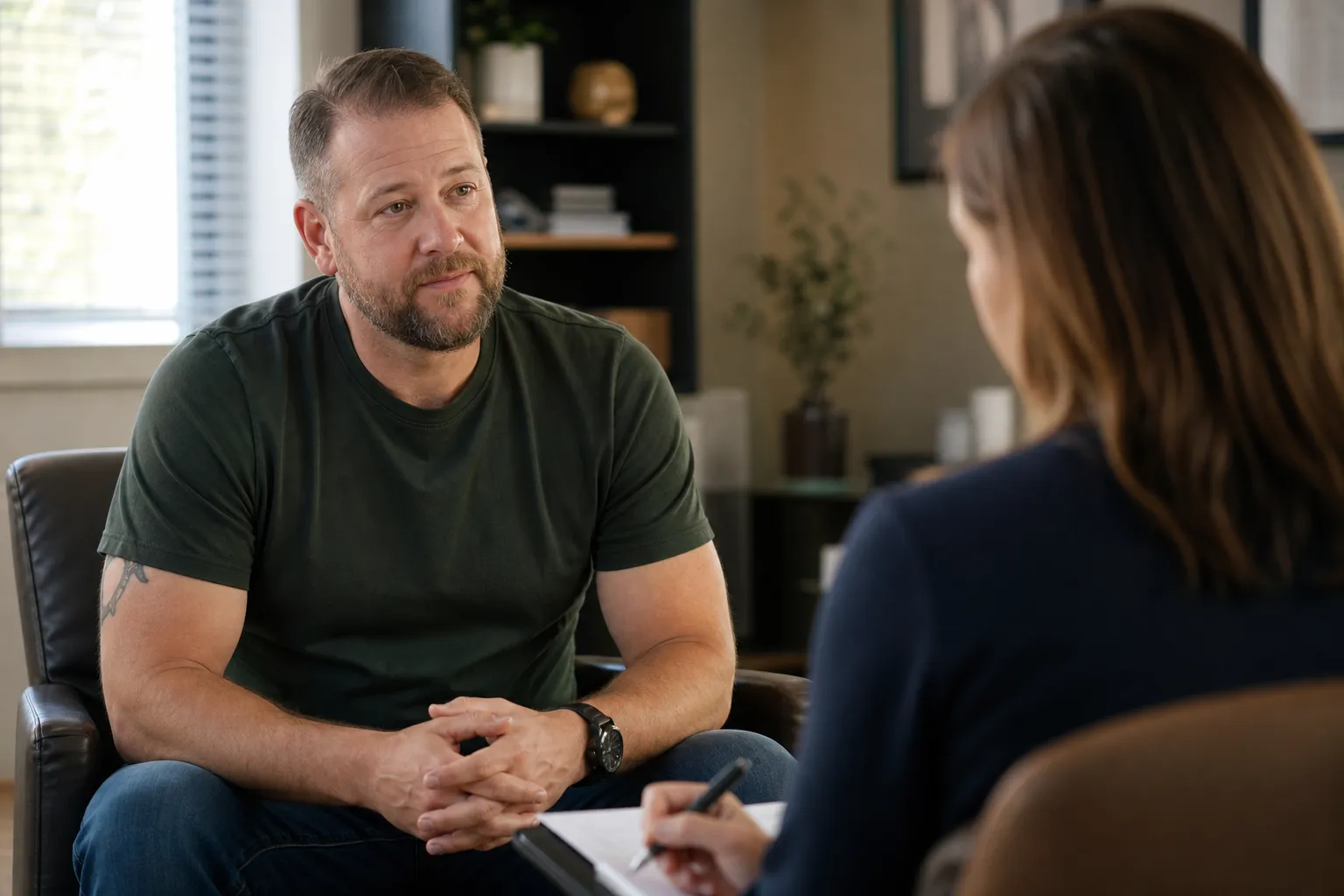 A veteran sitting across from a counselor during a mental health appointment in a calm office setting