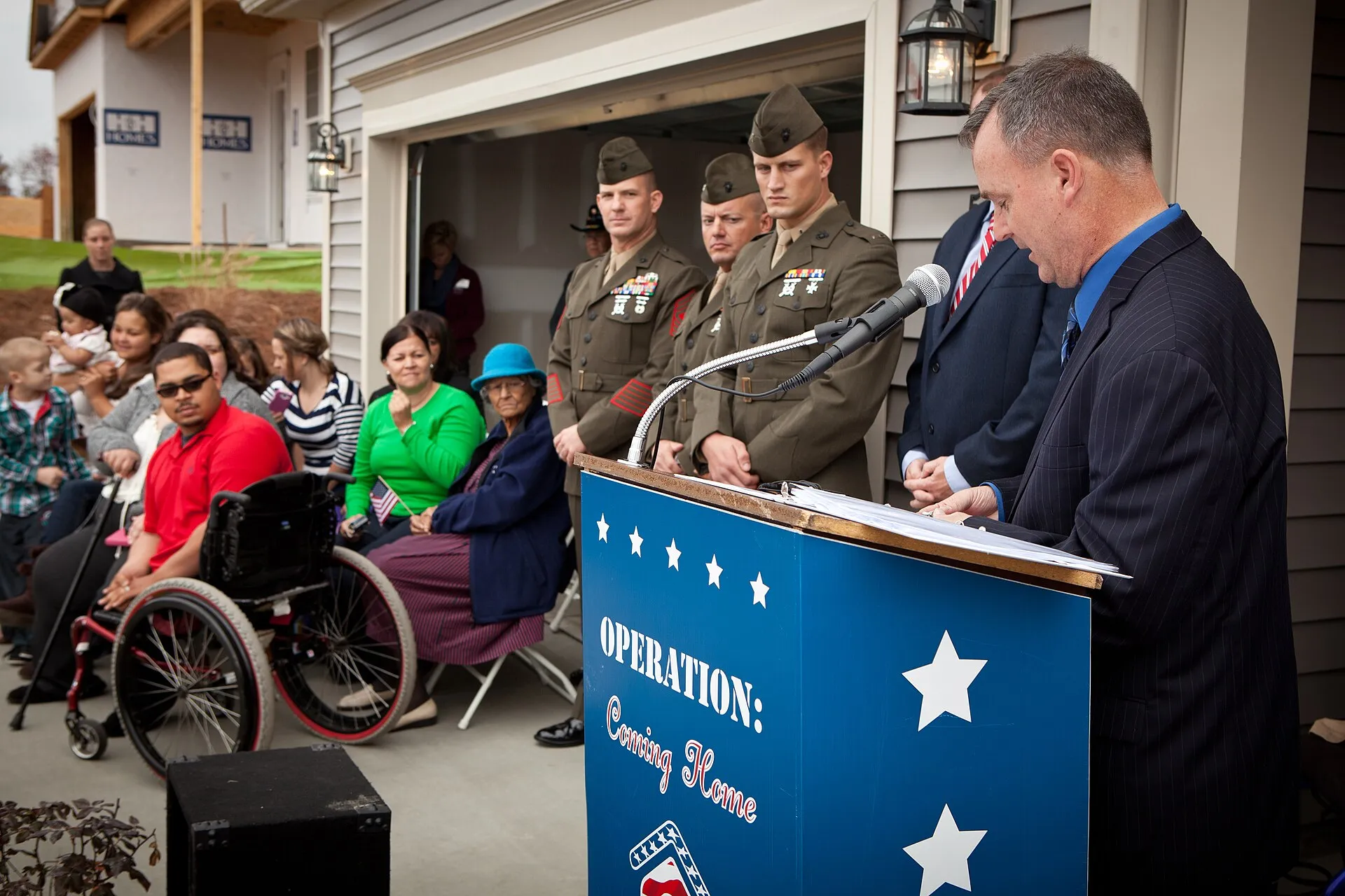 A military family standing in front of their new home holding the keys after closing on a VA-backed loan
